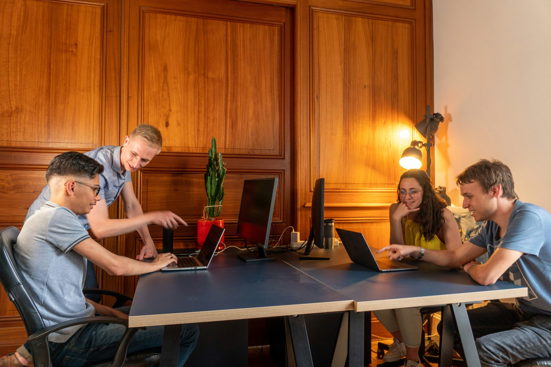 Group working at a wooden office desk.